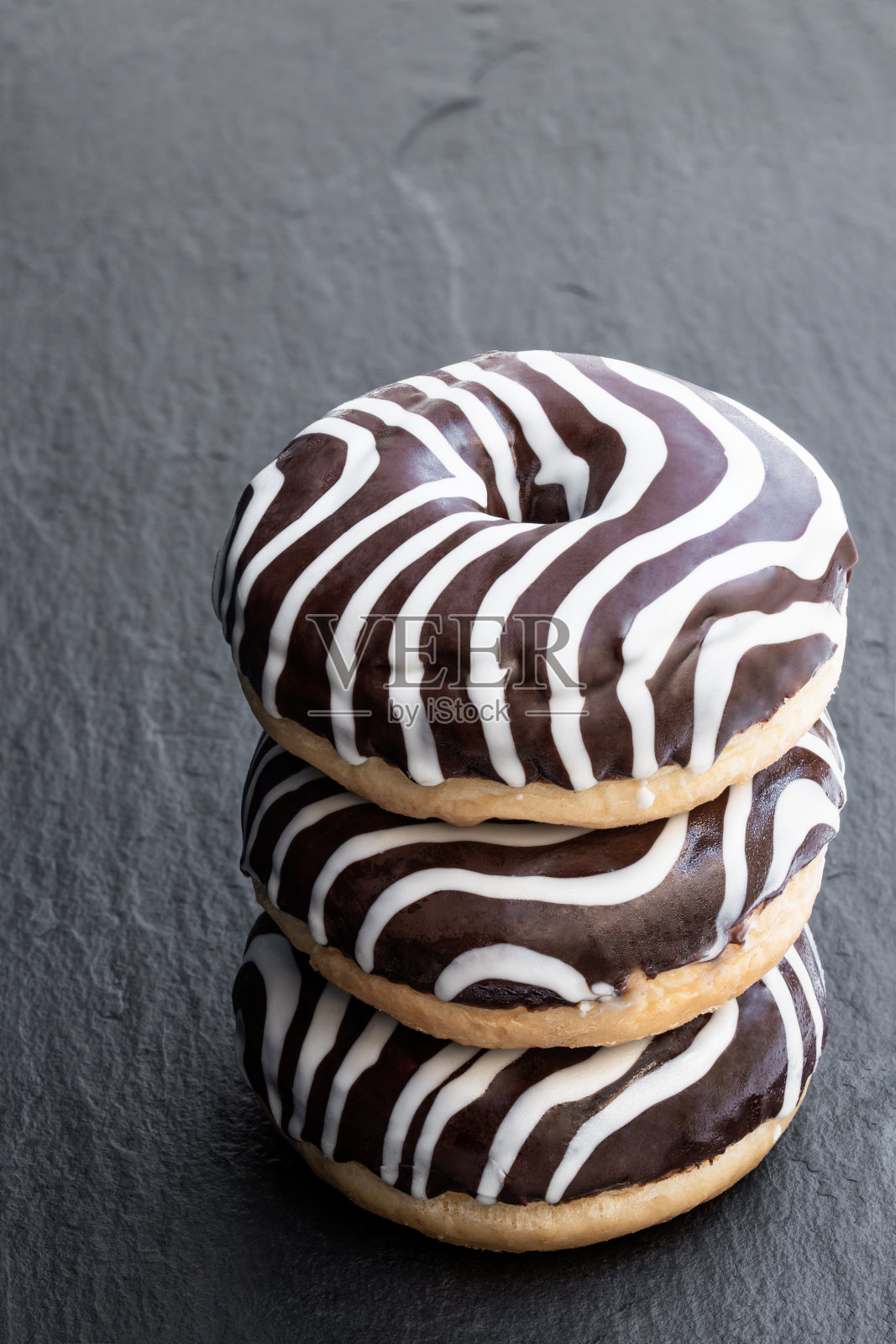 巧克力波纹条纹甜甜圈在黑色的石头背景照片摄影图片
