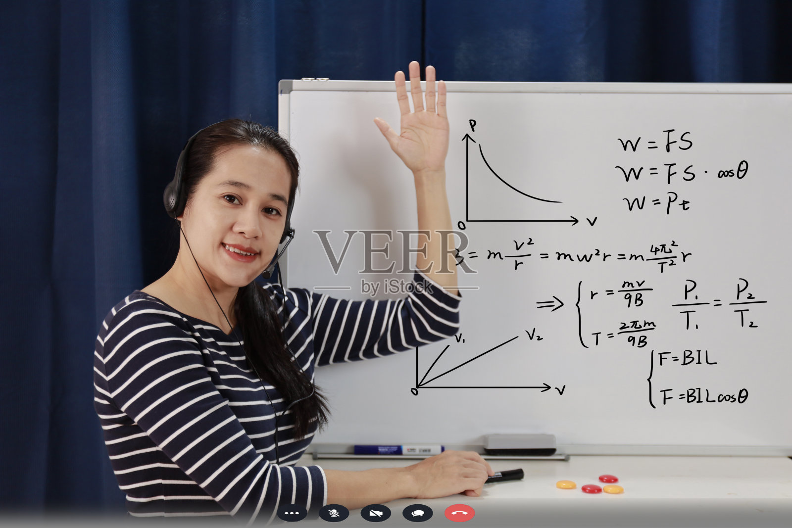 亚洲学校女教师工作在家教在线数学从家里学习的学生。新冠肺炎大流行期间，老师在白板上写字，戴着耳机在互联网课堂上讲课照片摄影图片