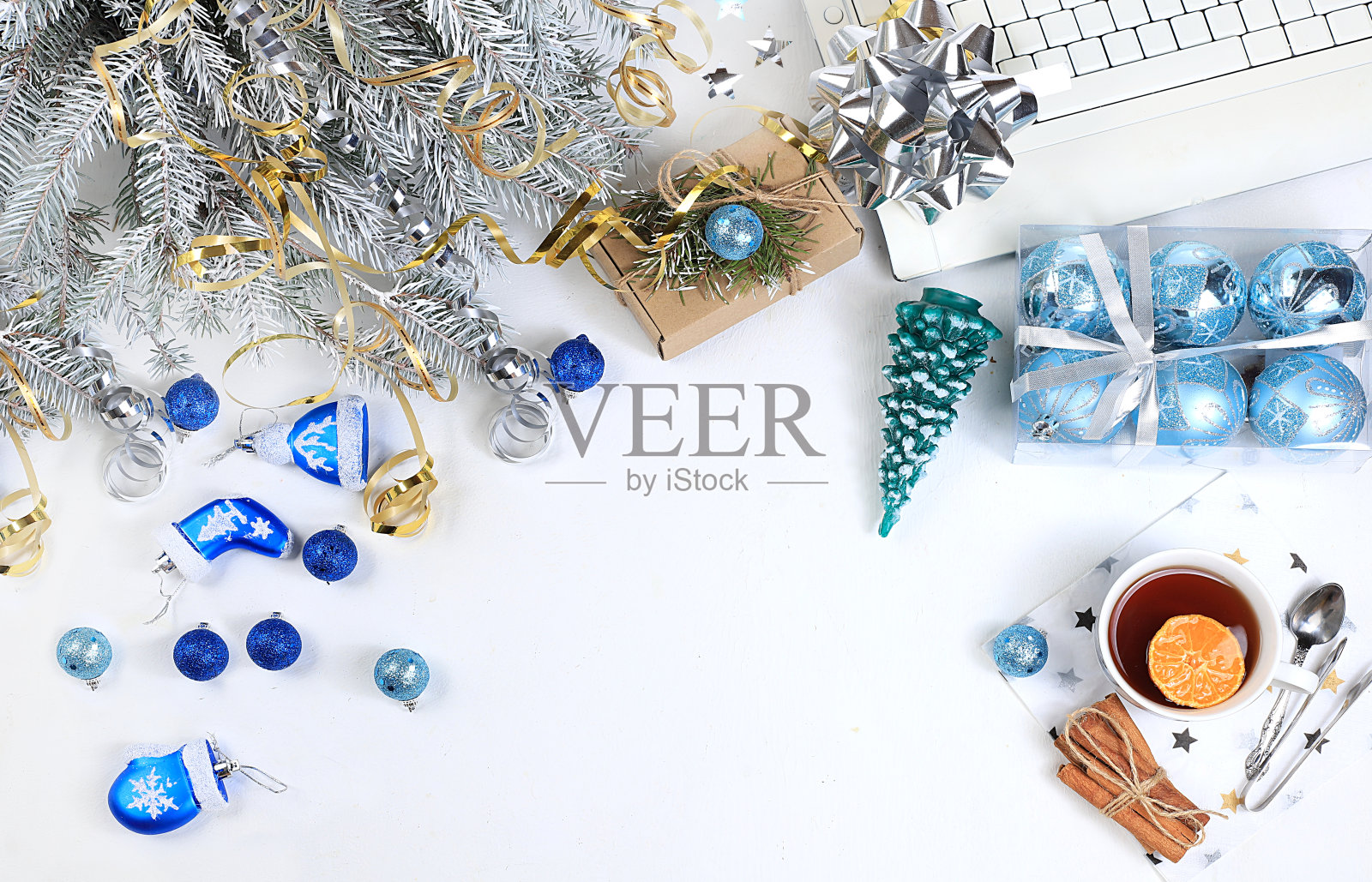 一个现代妇女的工作桌，准备迎接新年。电脑，圣诞装饰品，礼物和一杯茶，网上购物。生活理念，平铺，照片摄影图片