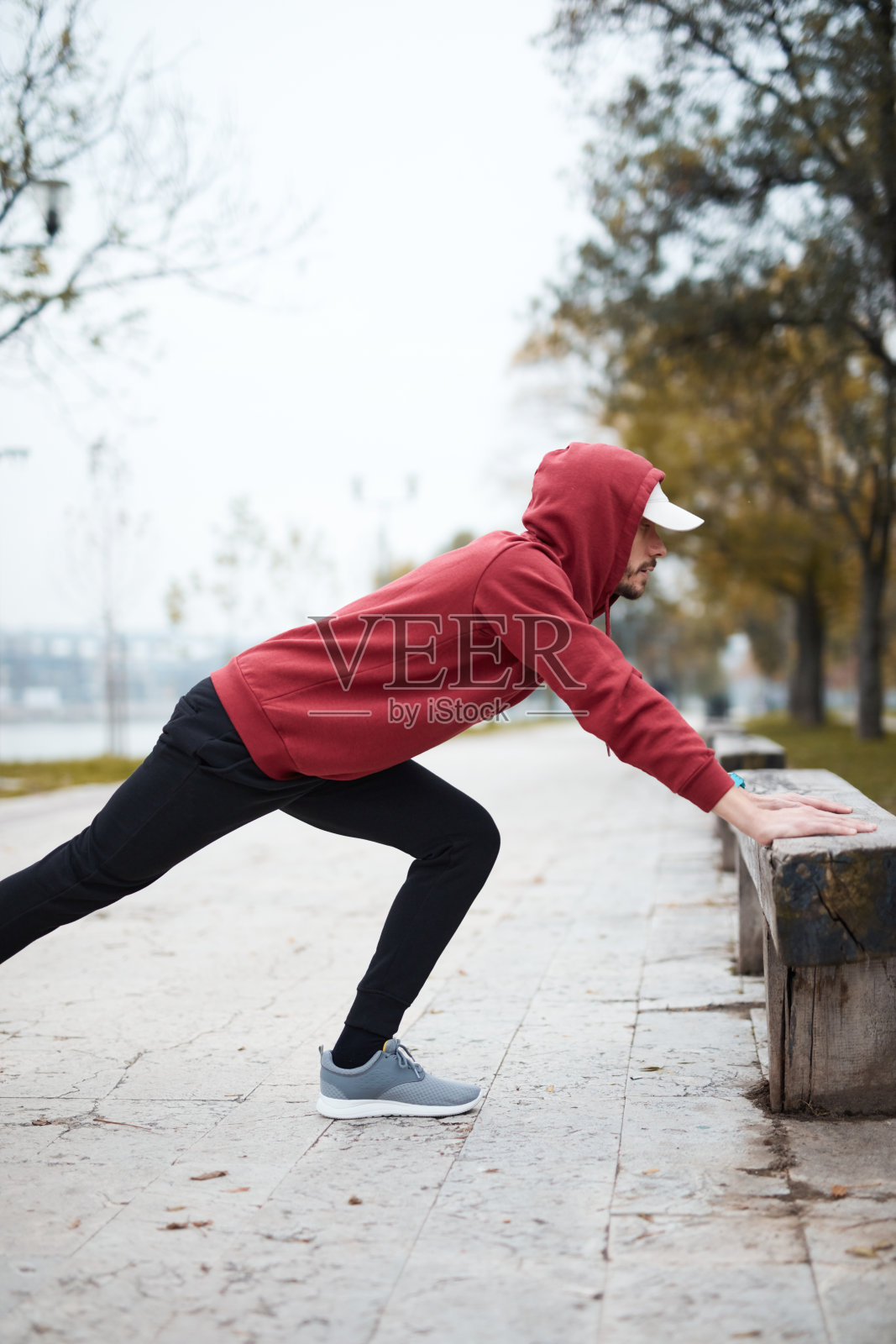 运动运动的人训练在城市公园帽衫。照片摄影图片