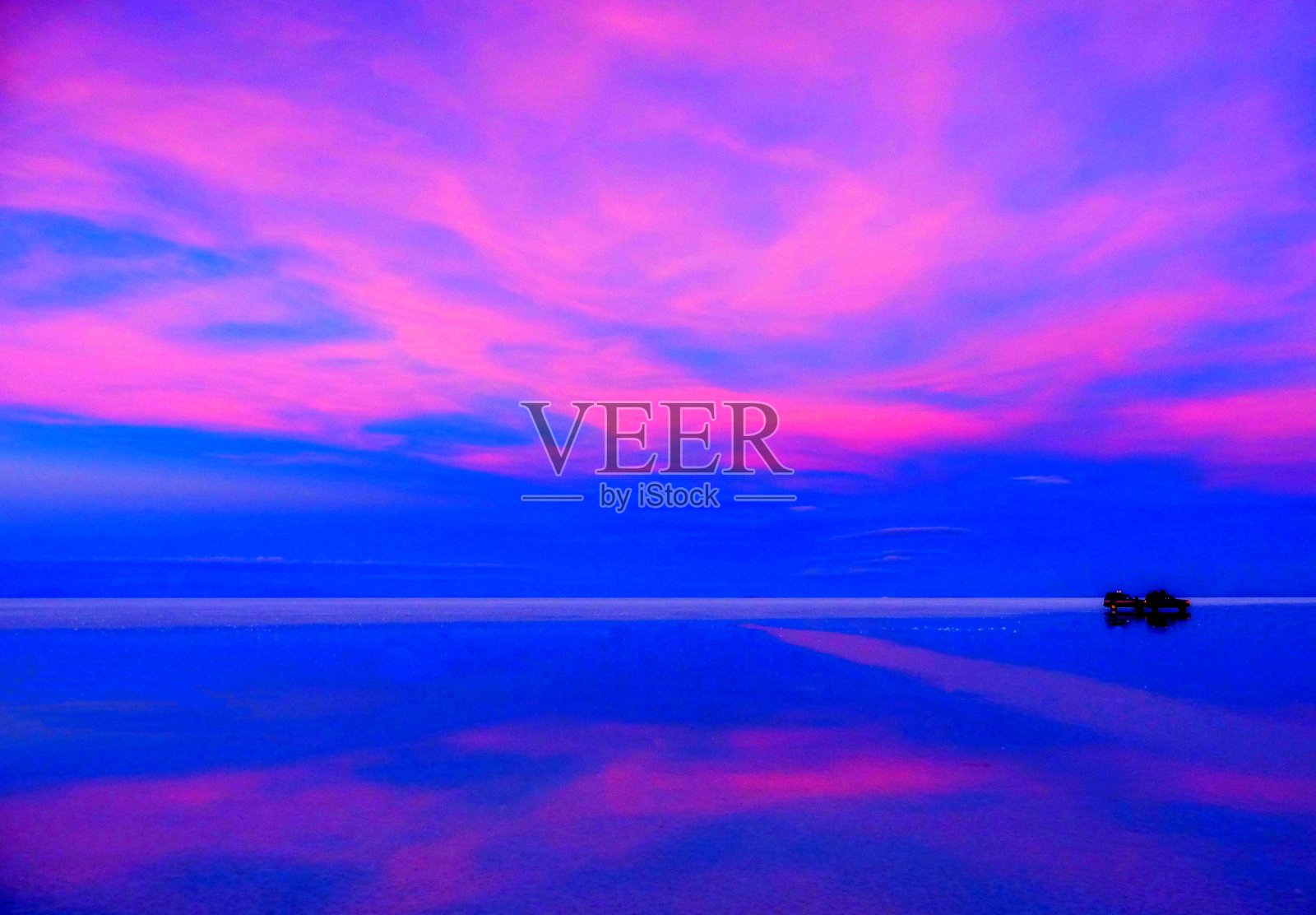 在玻利维亚乌尤尼盐滩上的沙漠湖上，霓虹粉蓝色超现实的夜晚日落天堂云景。神奇的外星景观。照片摄影图片