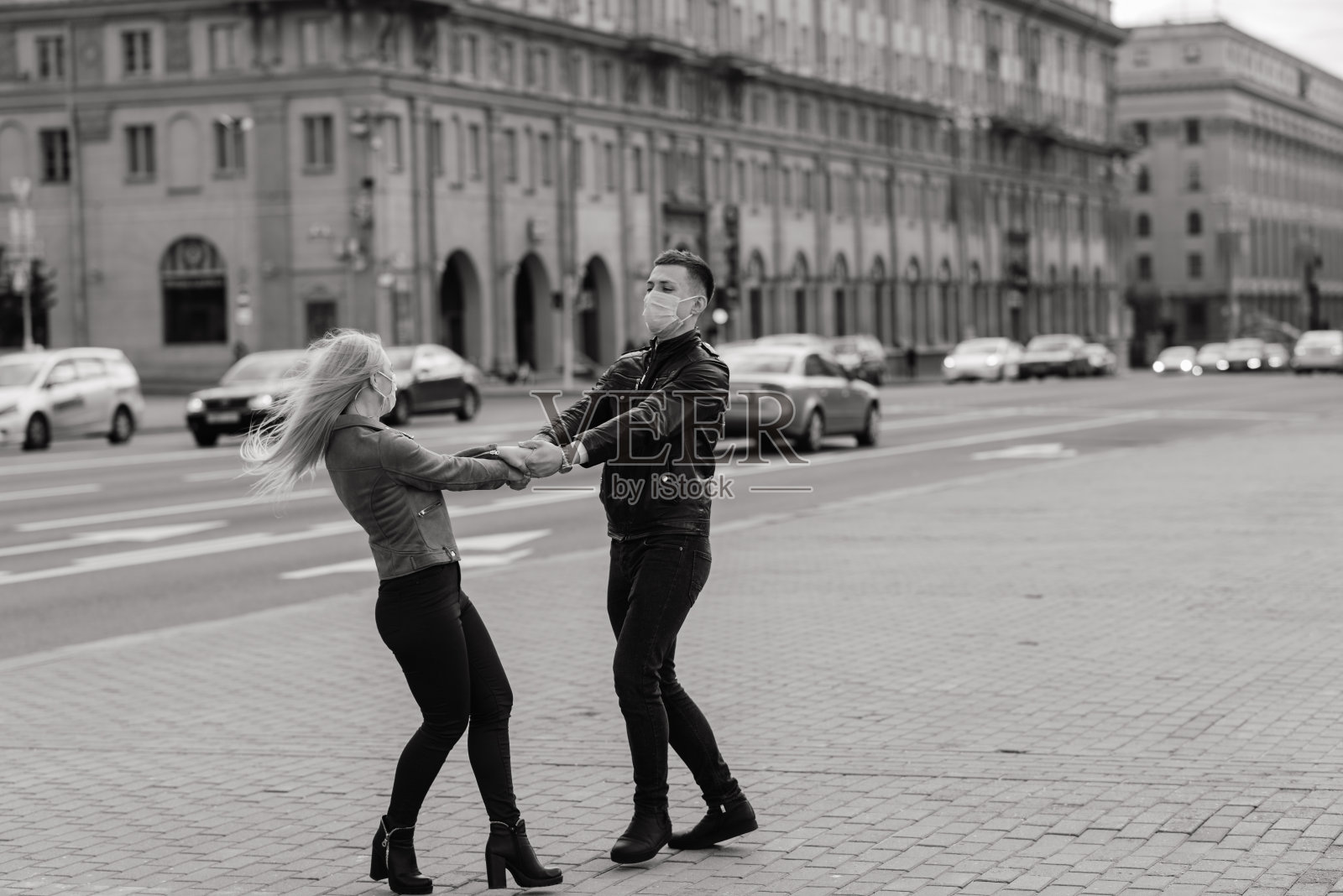 在新冠肺炎疫情传播期间，一对夫妇戴着医用口罩走在城市街道上。照片摄影图片