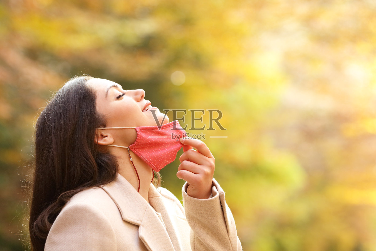 秋天，女人摘下口罩呼吸新鲜空气照片摄影图片