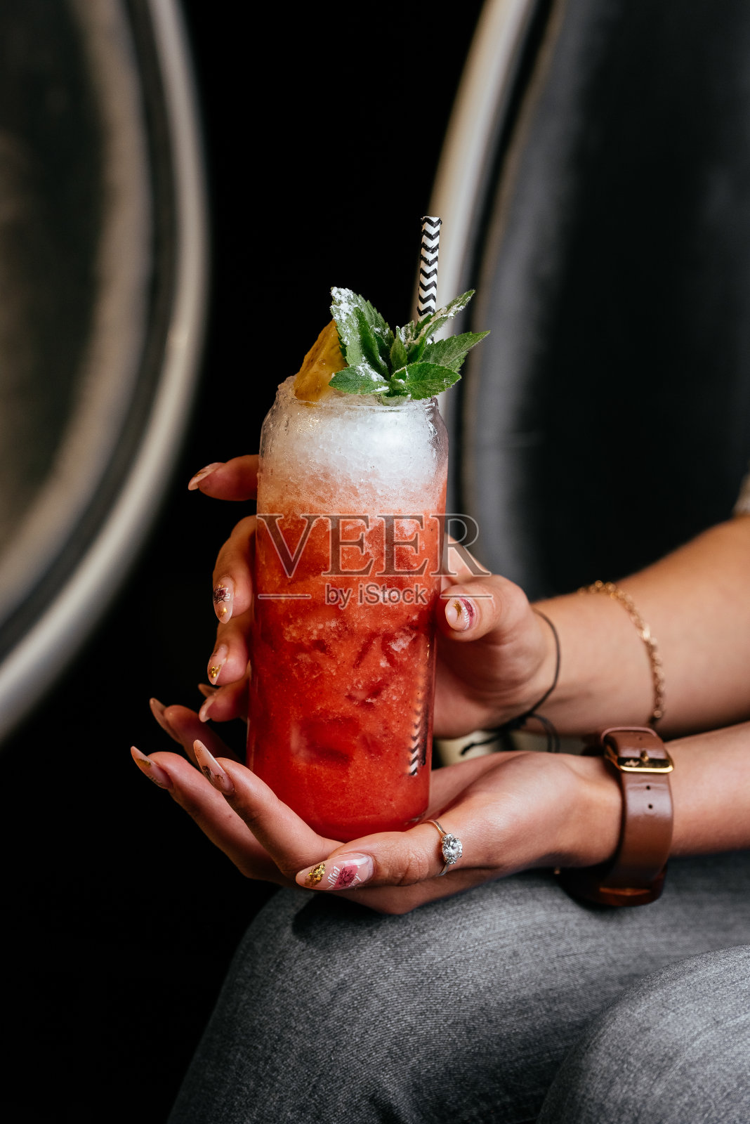 女士手中的黄色柑橘鸡尾酒照片摄影图片