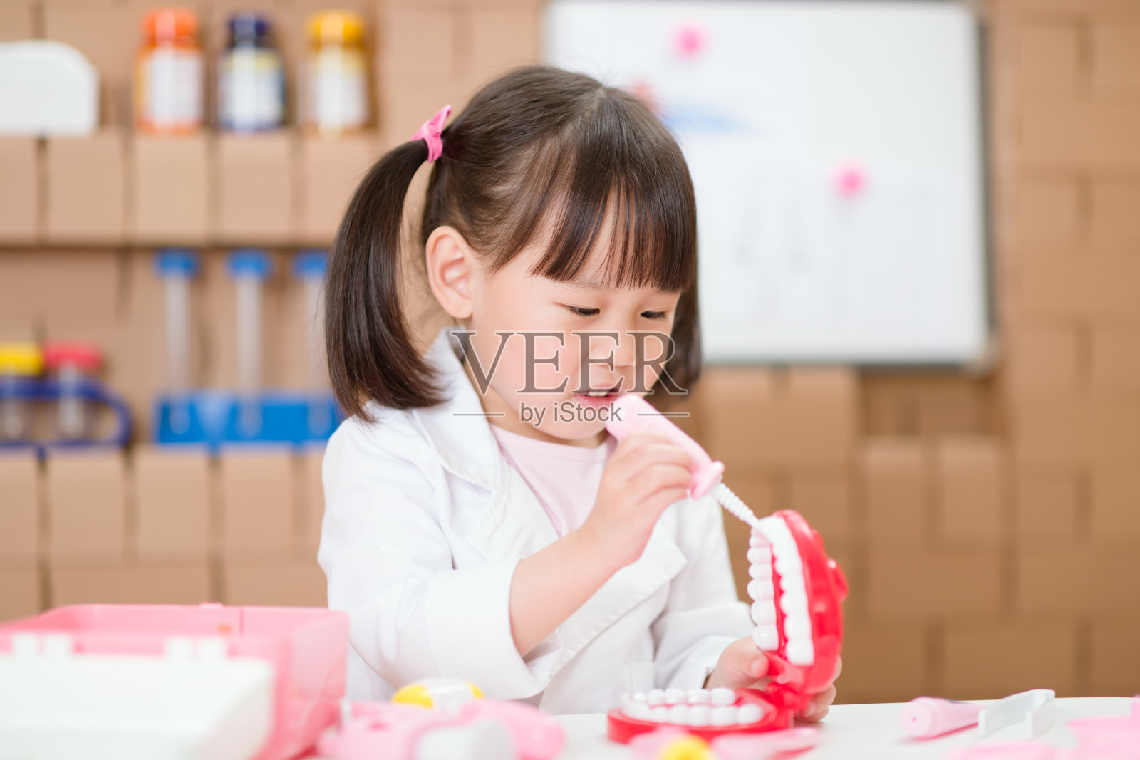 小女孩在家里假扮牙医照顾病人照片摄影图片