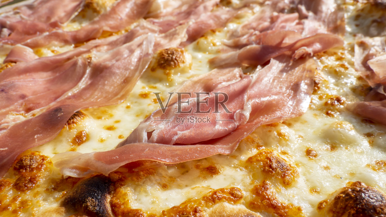 接近美味的意大利火腿披萨与马苏里拉奶酪(没有番茄)。用木烤箱烤的披萨照片摄影图片