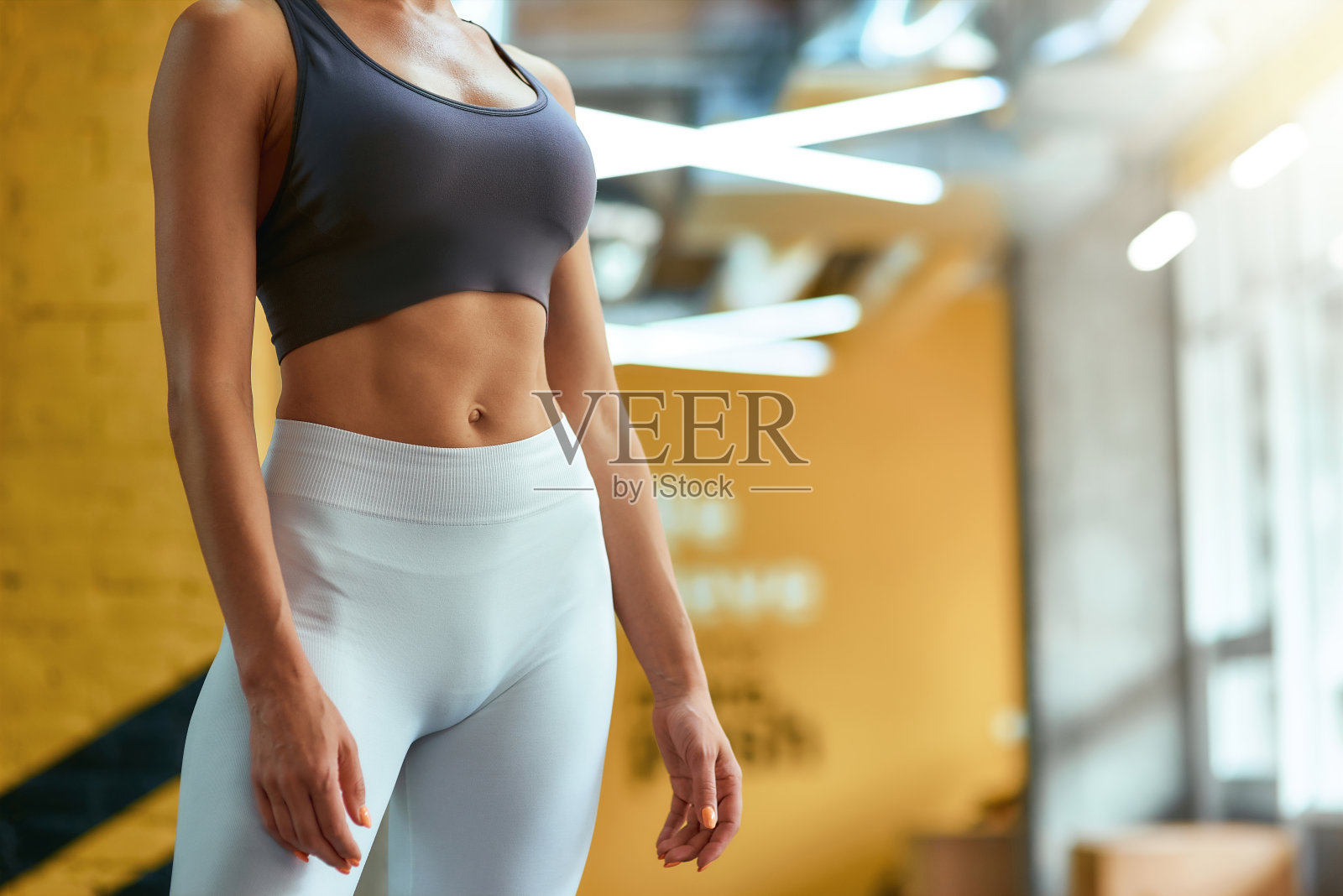 剪裁的运动健身女人在运动服与完美的腹肌站在健身房照片摄影图片