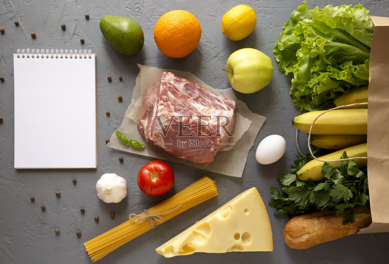 生食的纸袋，灰色表面上的空白记事本，俯视图。平躺着，从上面俯视。照片摄影图片