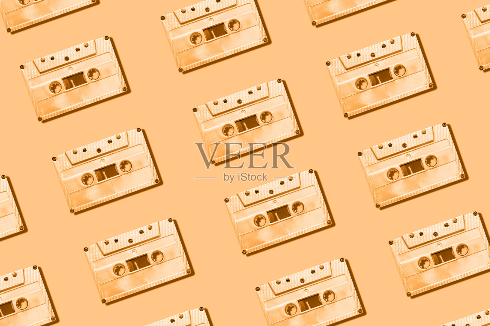 金色盒式磁带图案在奶油色的背景上有阴影照片摄影图片