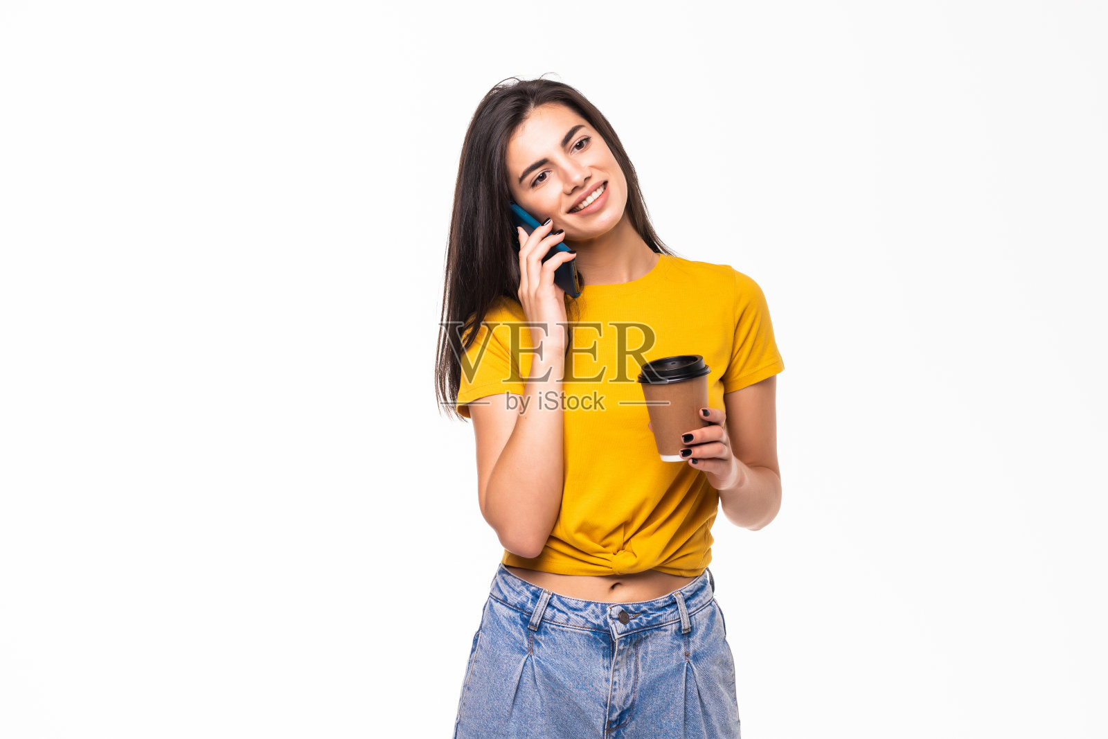 一个快乐的女人在用手机说话的肖像，同时拿着一杯咖啡去孤立的白色背景照片摄影图片