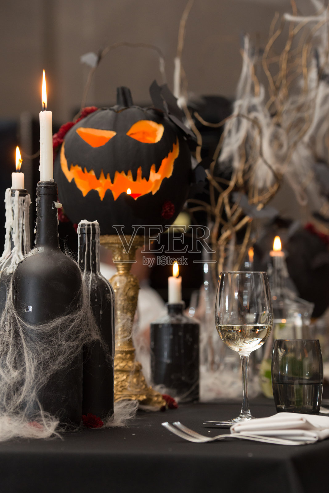 万圣节晚餐的餐桌。节日餐桌上放着蜡烛和南瓜照片摄影图片