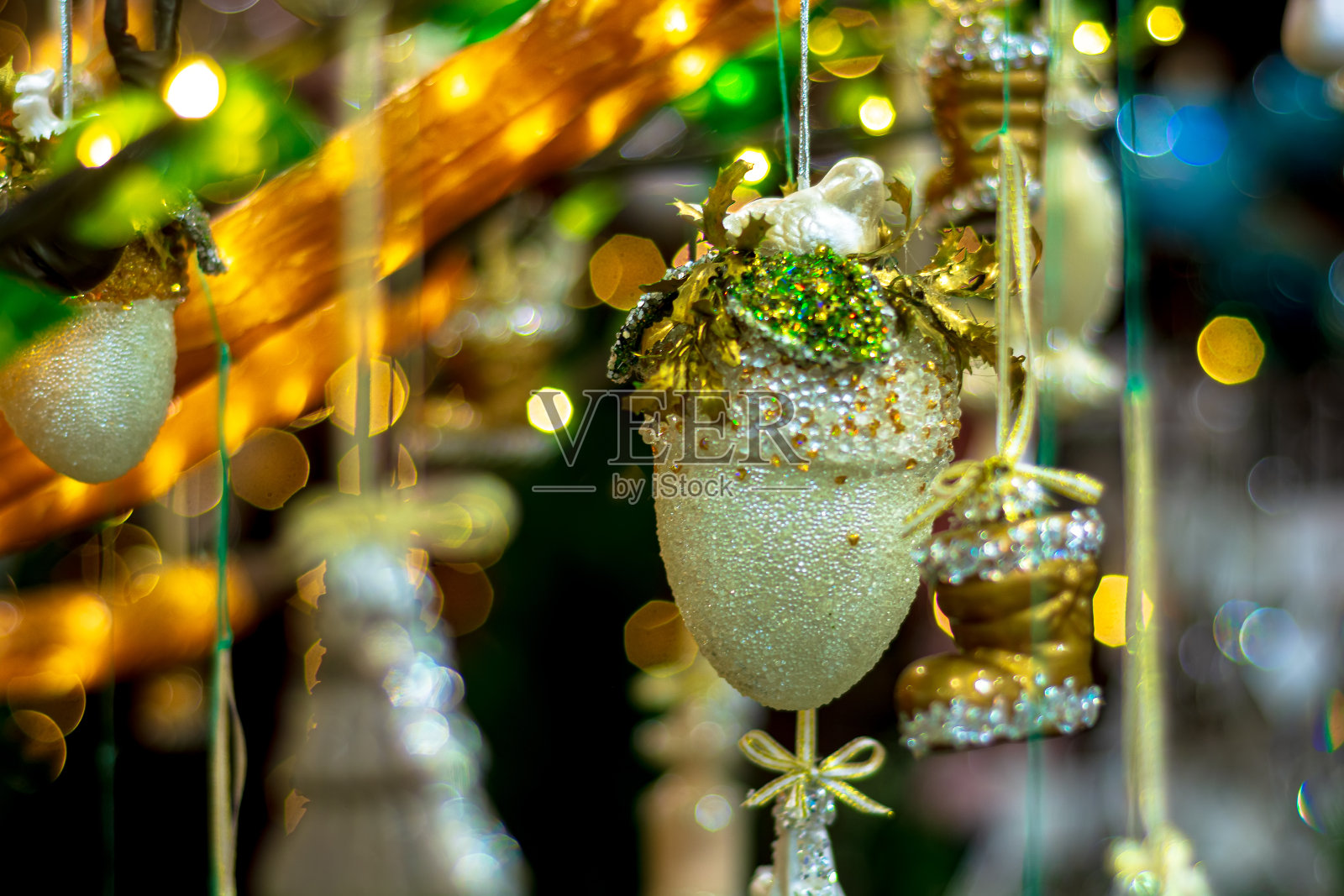 圣诞玩具挂在装饰着花环的树的树枝上。景深浅。照片摄影图片