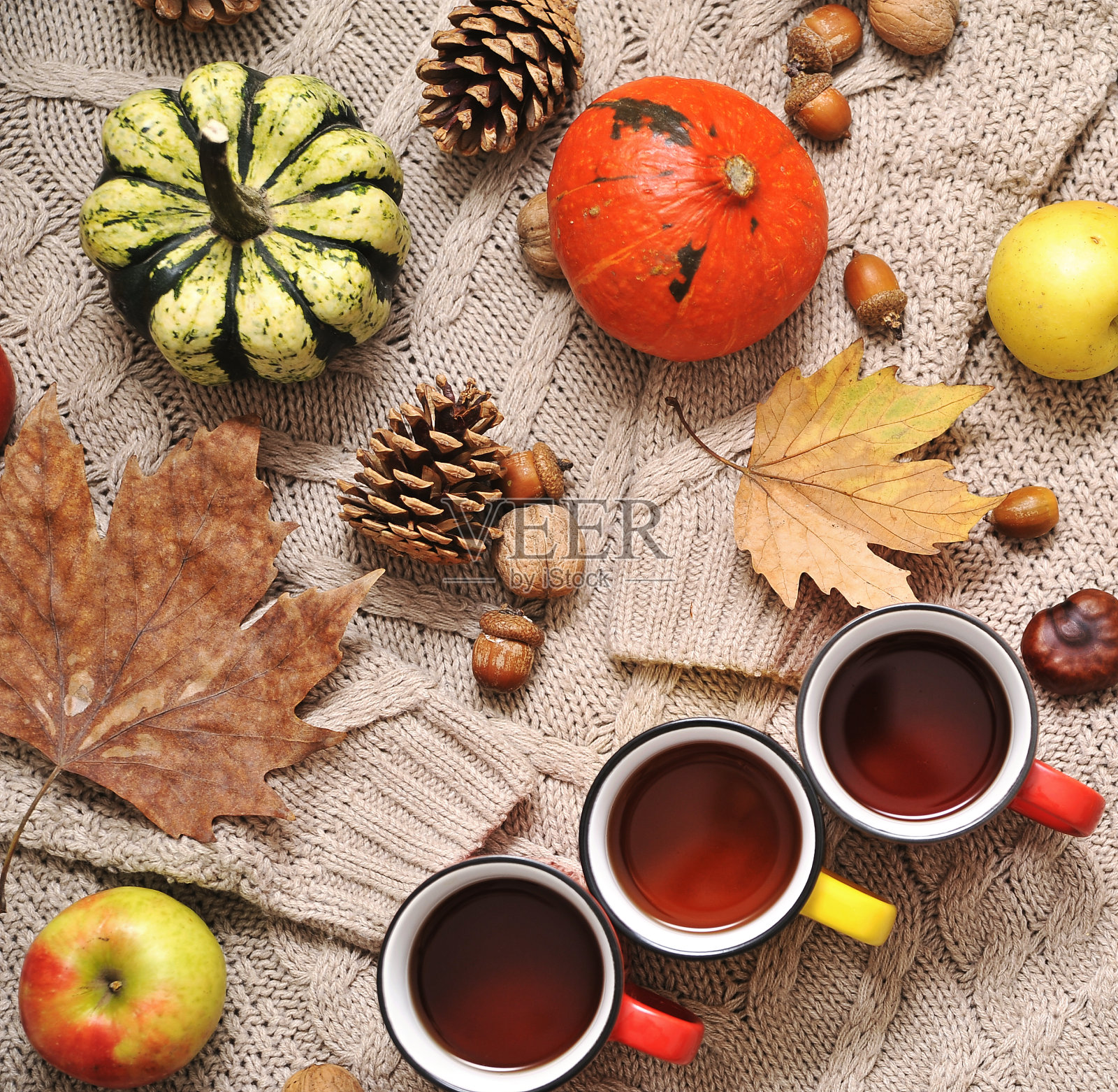 秋平奠定背景。南瓜，苹果，坚果，树叶，杯子和毛衣的木制背景。照片摄影图片