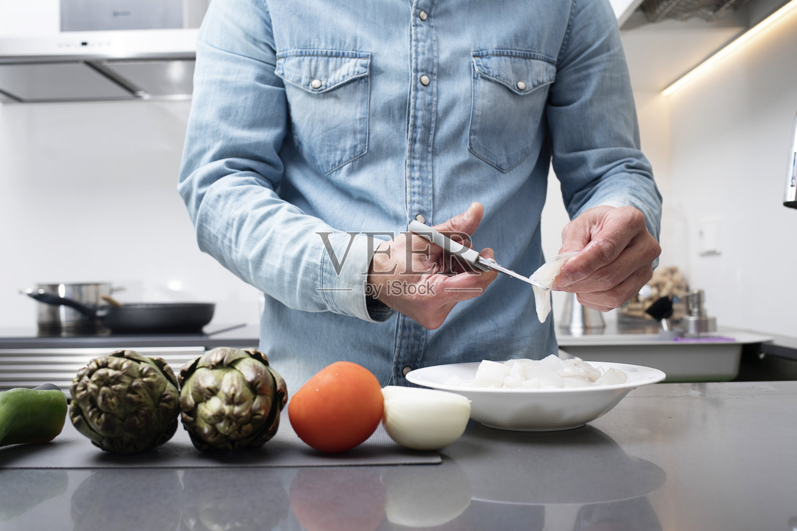 男性在厨房的菜板上切蔬菜的裁剪视图照片摄影图片