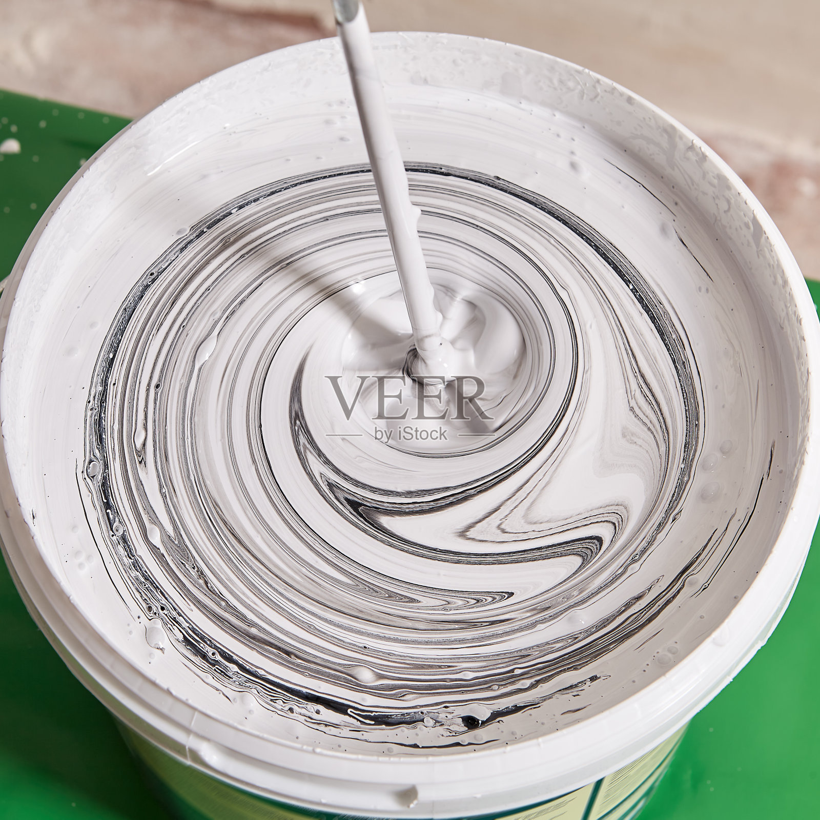 在装修期间，勤杂工用钻孔制作颜色来粉刷墙壁。照片摄影图片