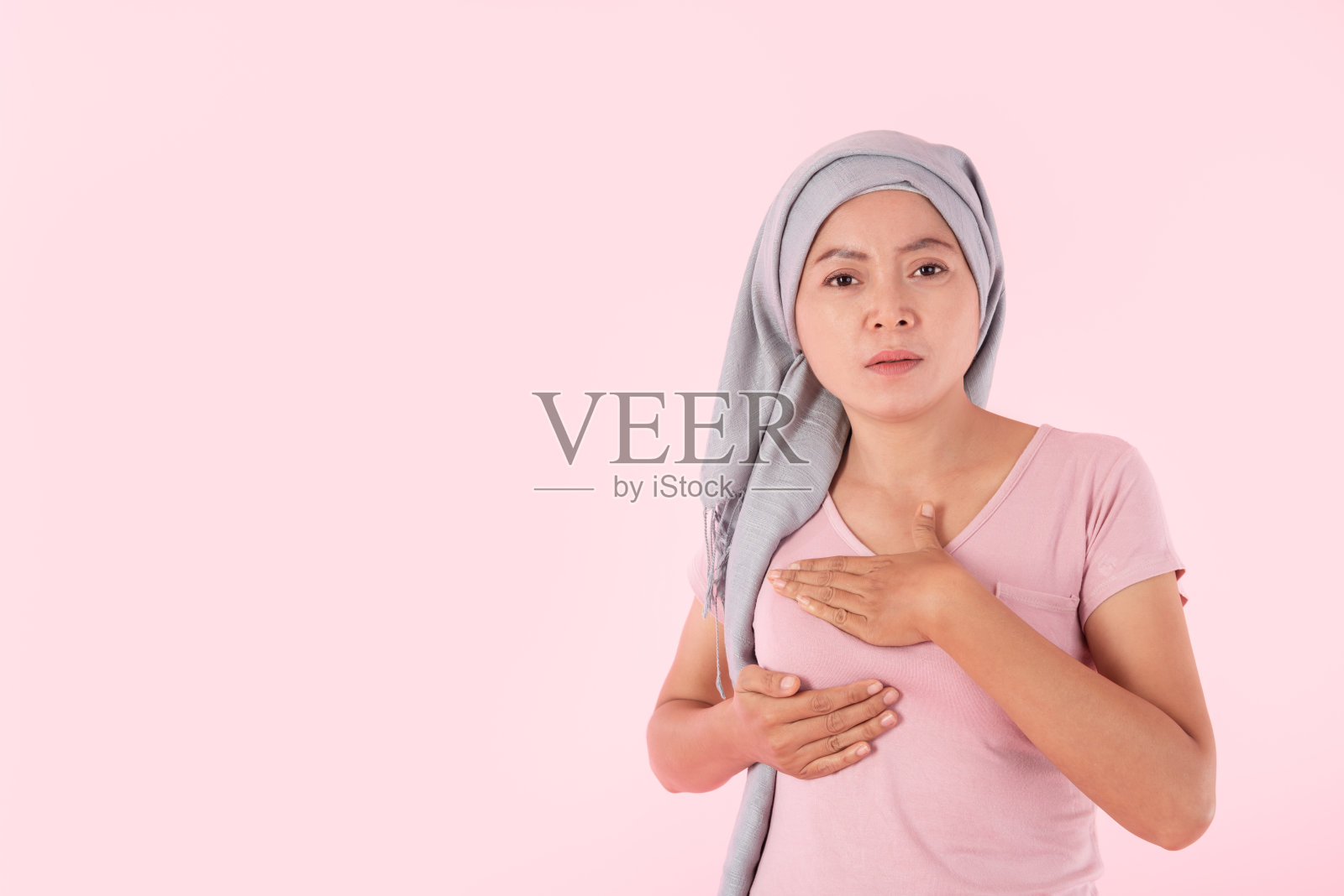 年轻女子乳房疼痛触摸胸部粉红色的背景照片摄影图片