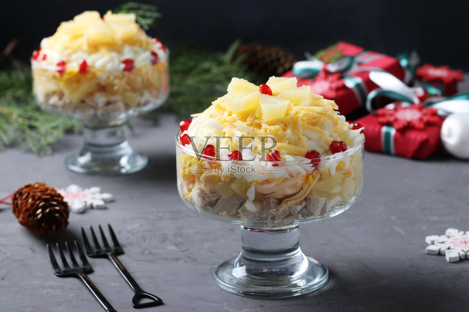 节日沙拉，鸡肉，菠萝，奶酪和鸡蛋，呈深灰色背景。新年静物生活。水平格式照片摄影图片