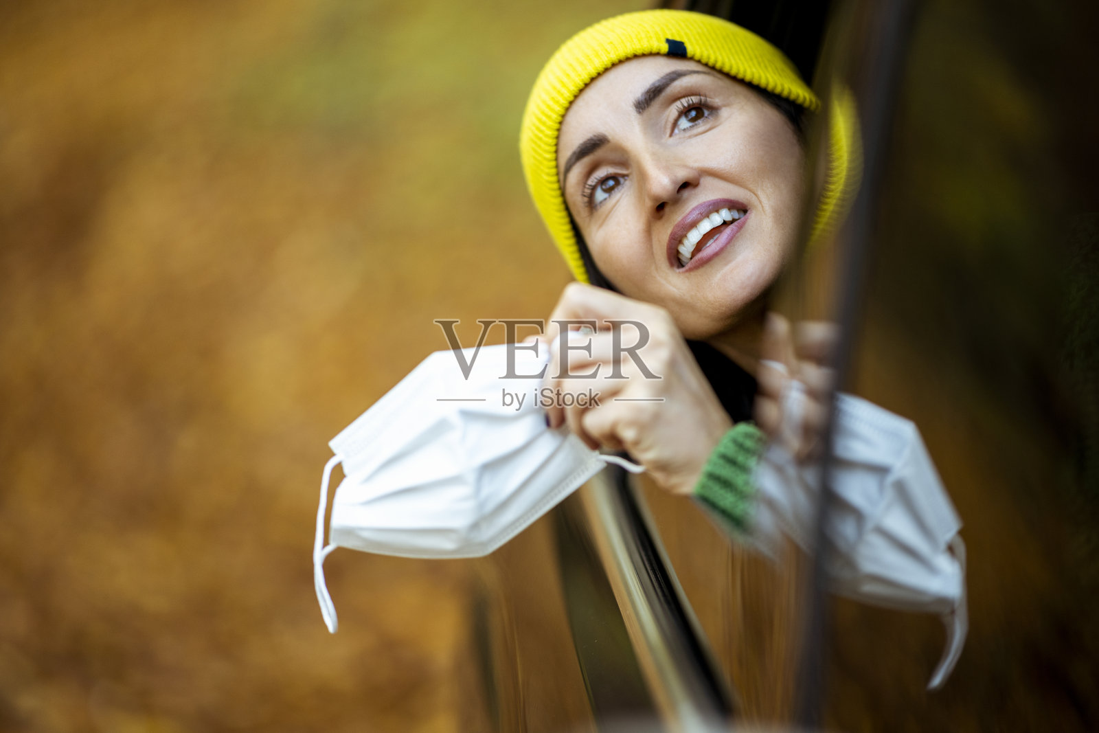 快乐的女人摘下面具，呼吸新鲜空气照片摄影图片