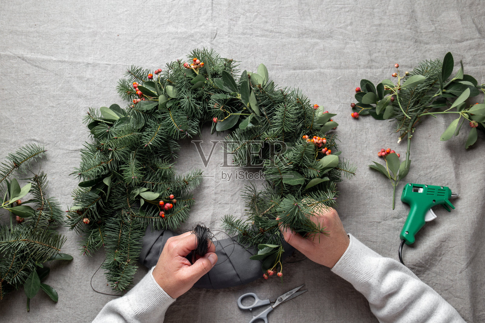人们正在制作圣诞花环。新年节日装饰照片摄影图片
