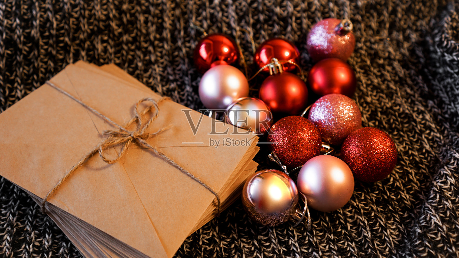 一堆用牛皮纸写的信件，上面有圣诞红和粉色的球照片摄影图片