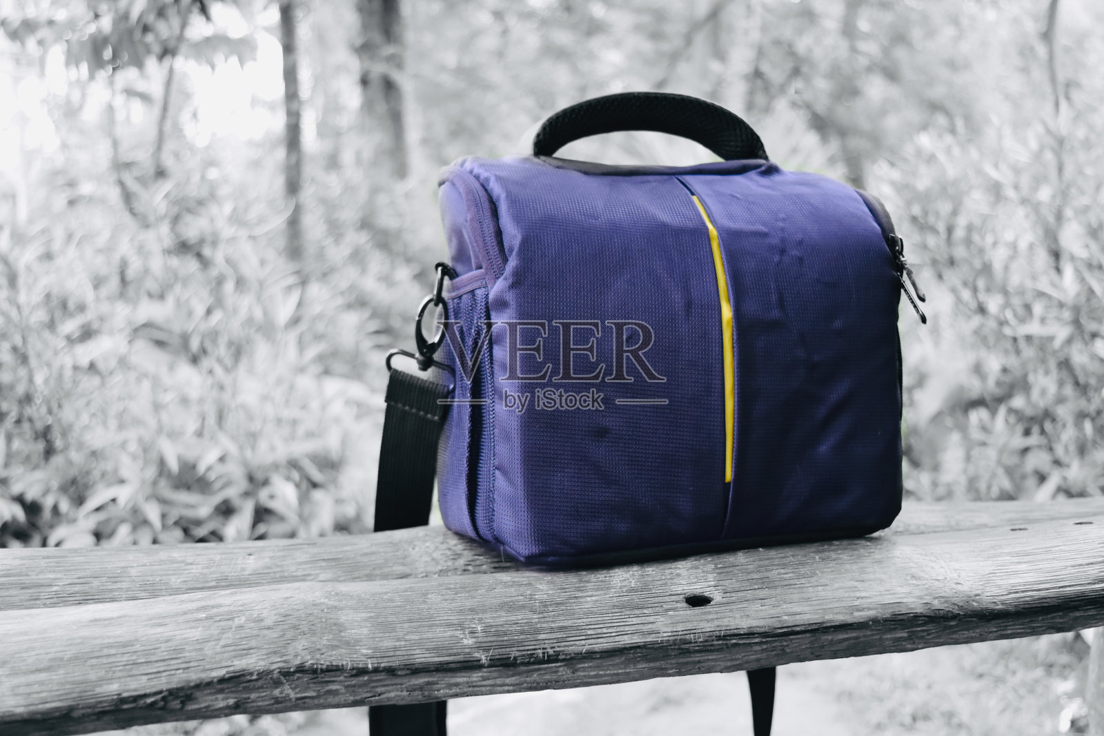 坐在长椅上的蓝色相机包照片摄影图片