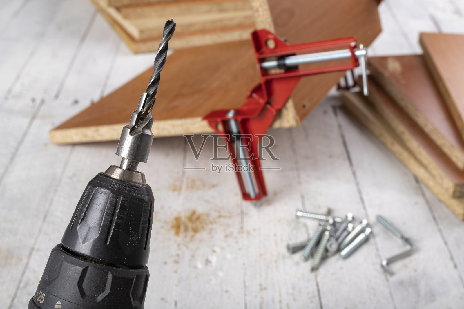 有棱角的木工夹上的刨花板。用专用螺钉连接家具板材。光背景。照片摄影图片