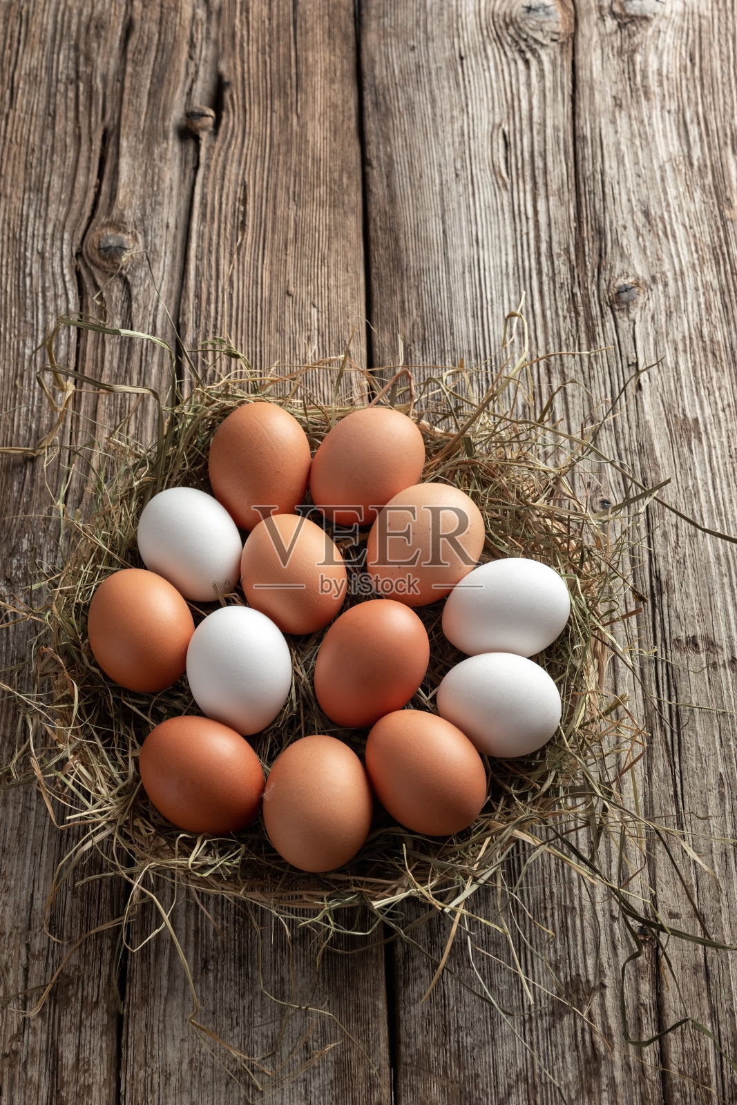 生鸡蛋和干草放在篮子里照片摄影图片