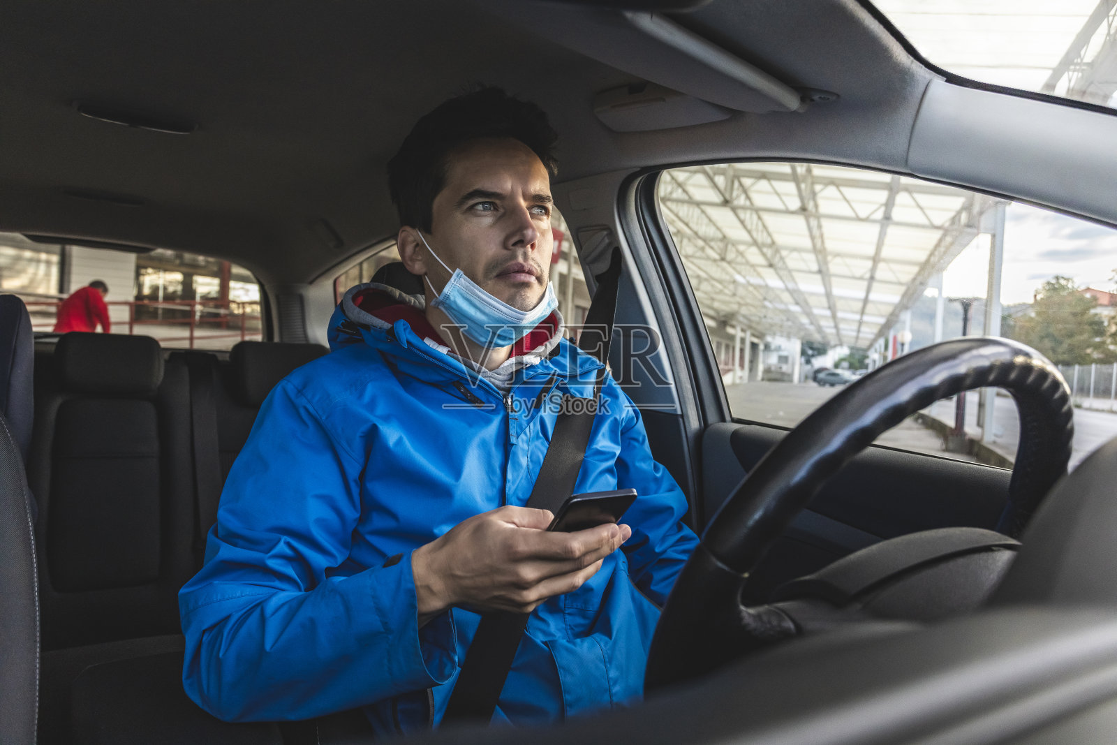 停车场司机戴口罩在车内使用手机照片摄影图片