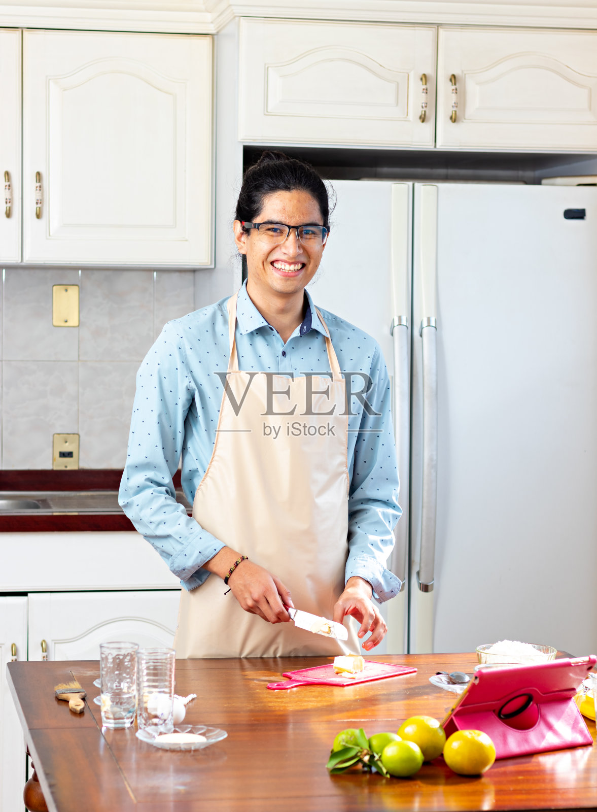 一个男人在厨房里，拿着刀切黄油照片摄影图片