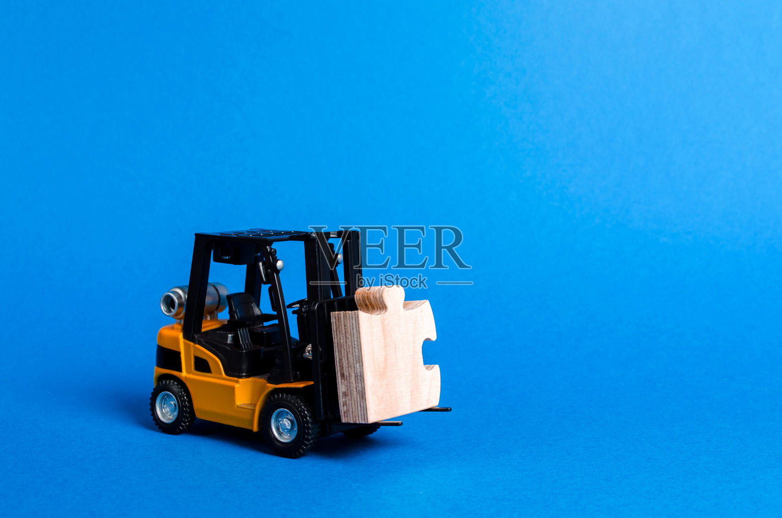 铲车承载着拼图的一部分。业务流程和全球化概念。以利基市场为例。参与一个大型项目或经济过程。投资。启动,集资”。照片摄影图片