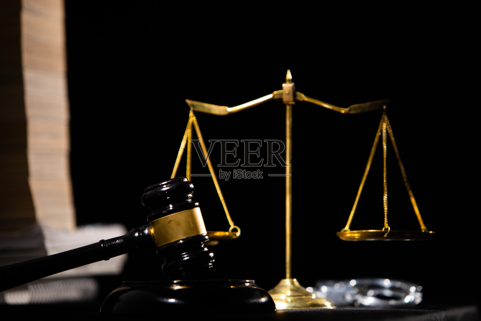 用于正义和审判的平衡秤与手铐、法律书和锤子照片摄影图片