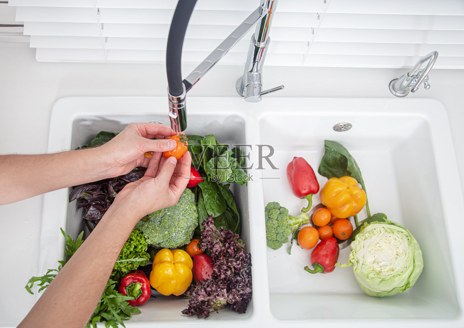 女人的手洗蔬菜做素食沙拉俯视图。照片摄影图片