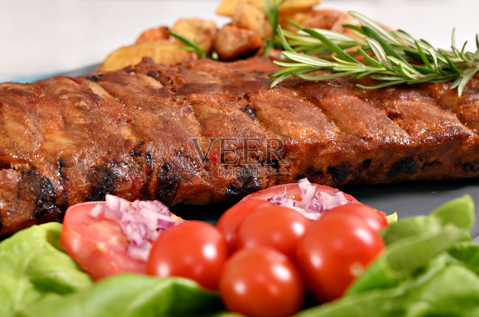 猪排，土豆和西红柿在盘子里照片摄影图片