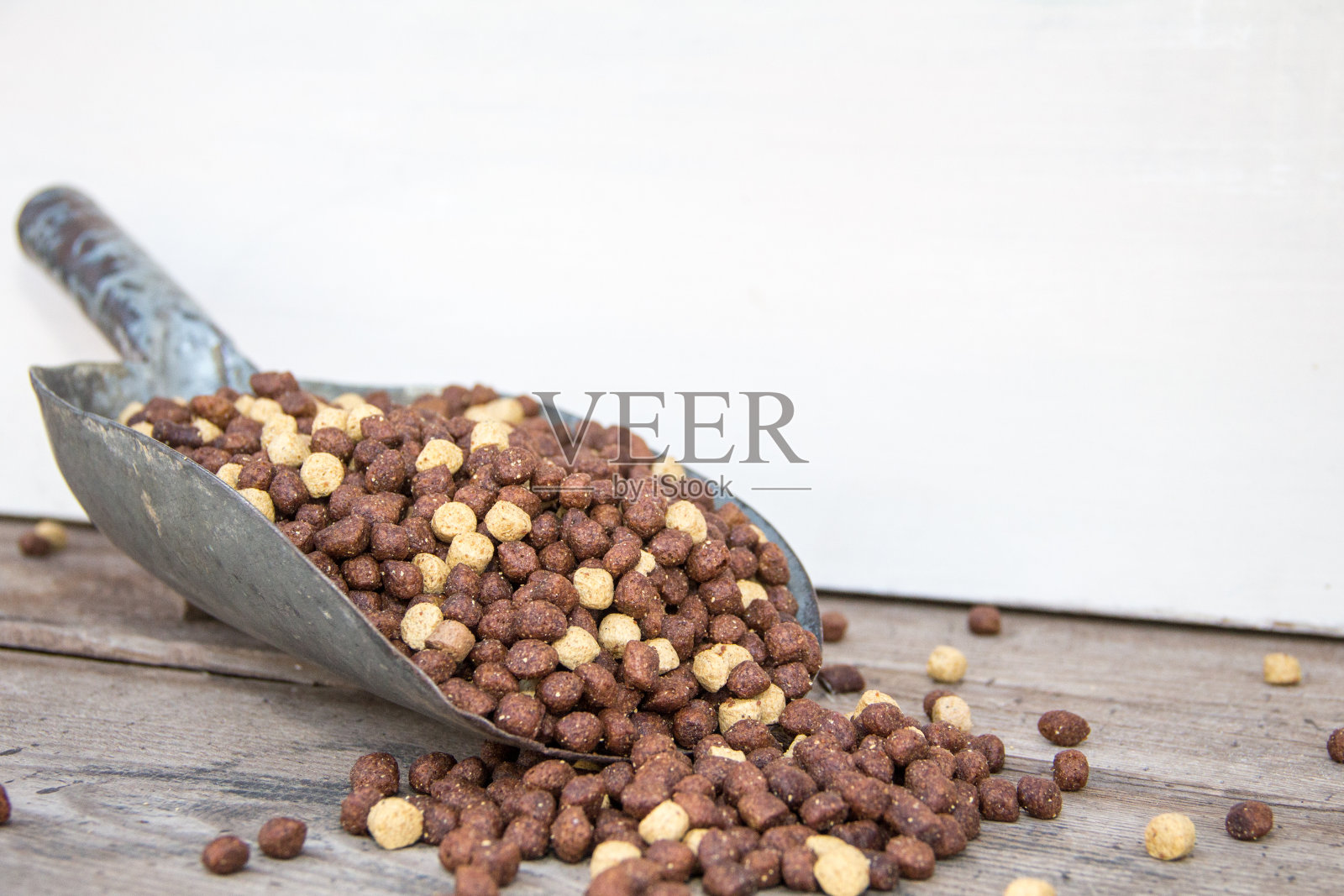 木制的背景上装满了狗和猫的食物颗粒的铲子照片摄影图片