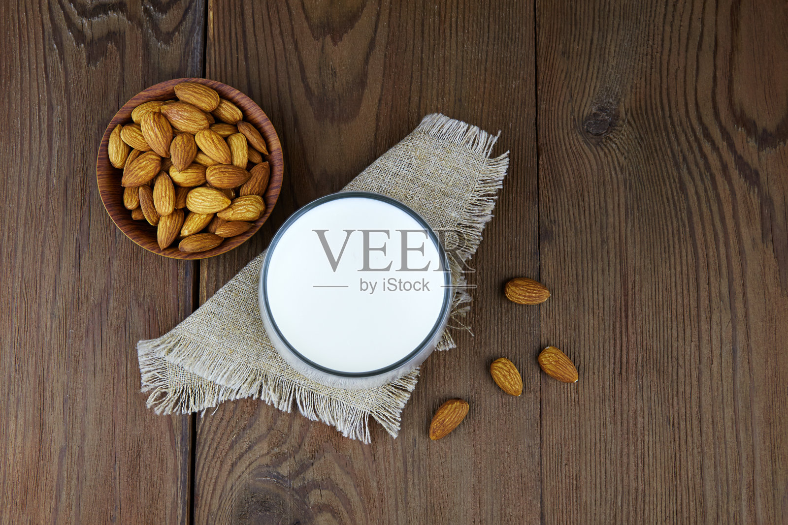 一杯杏仁牛奶和杏仁坚果。健康坚果素食，素食饮品概念。照片摄影图片