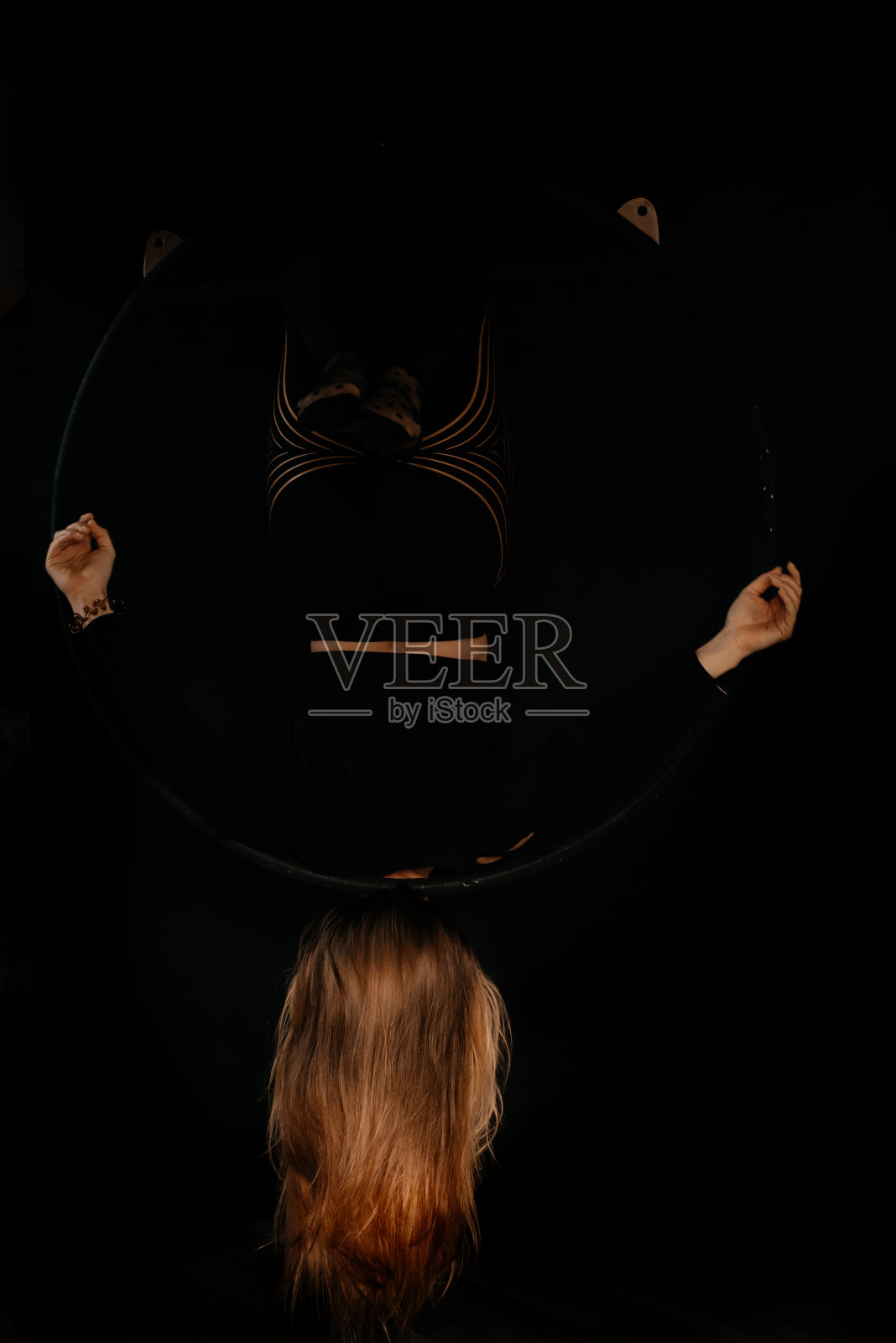 黑发女孩在空中体操环上。照片摄影图片