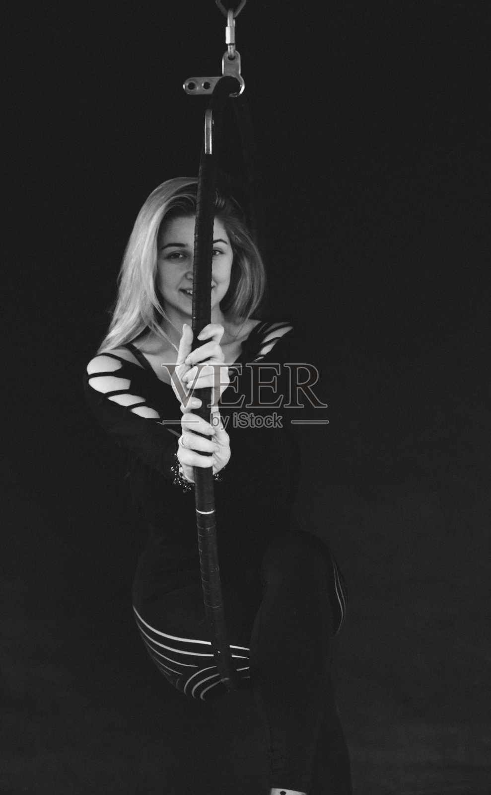 女子体操运动员在体操环上表演杂技元素。照片摄影图片