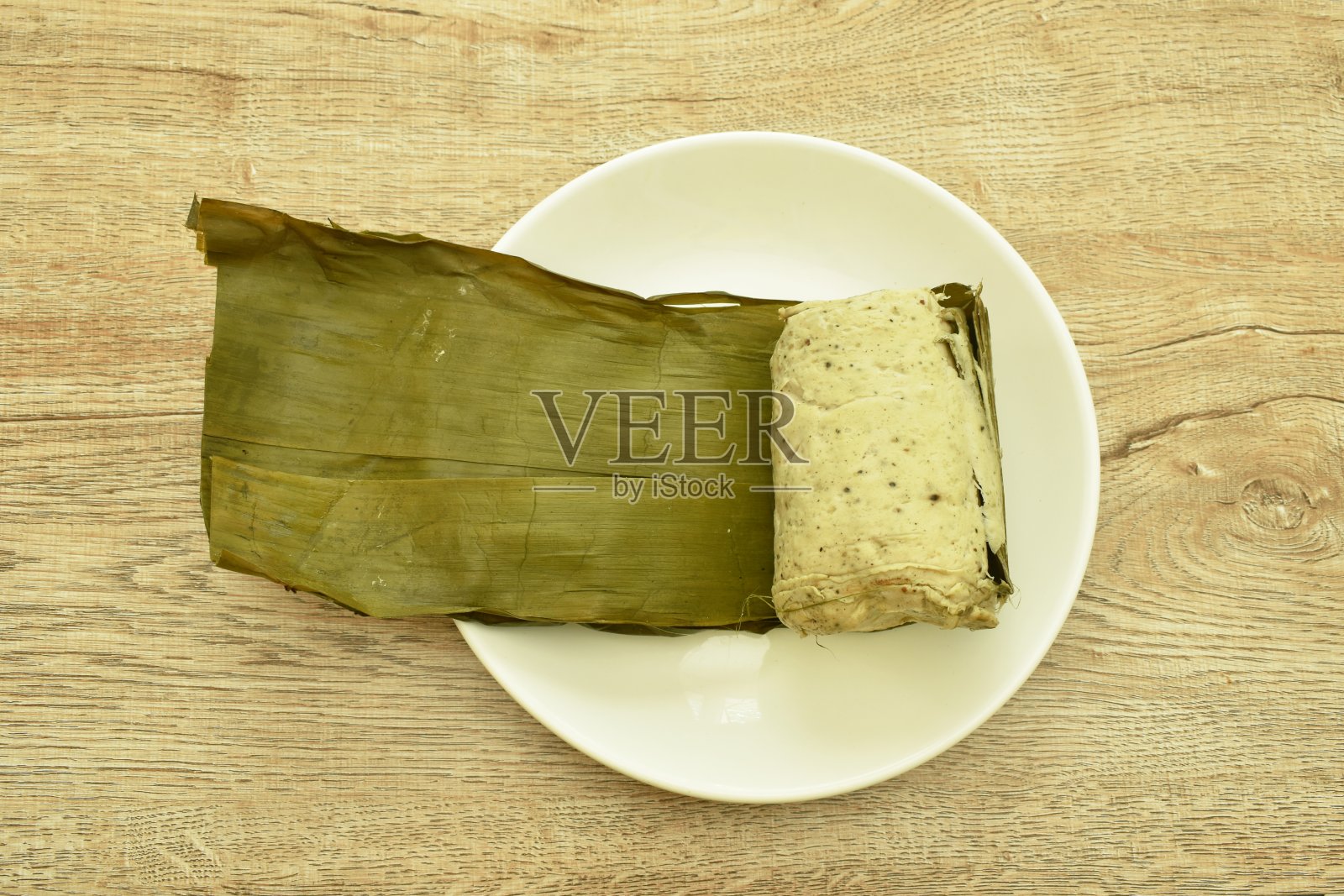 越南风味的猪肉泥和蘑菇香肠，用绿香蕉叶包装照片摄影图片
