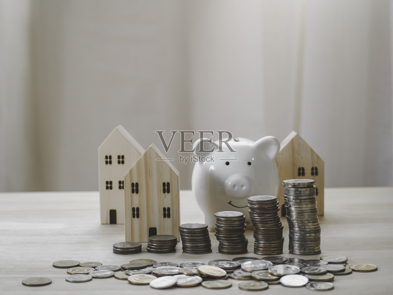 存钱罐、钱币堆成长图和木房子模型。投资于房地产业务。概念储蓄，面向未来。照片摄影图片