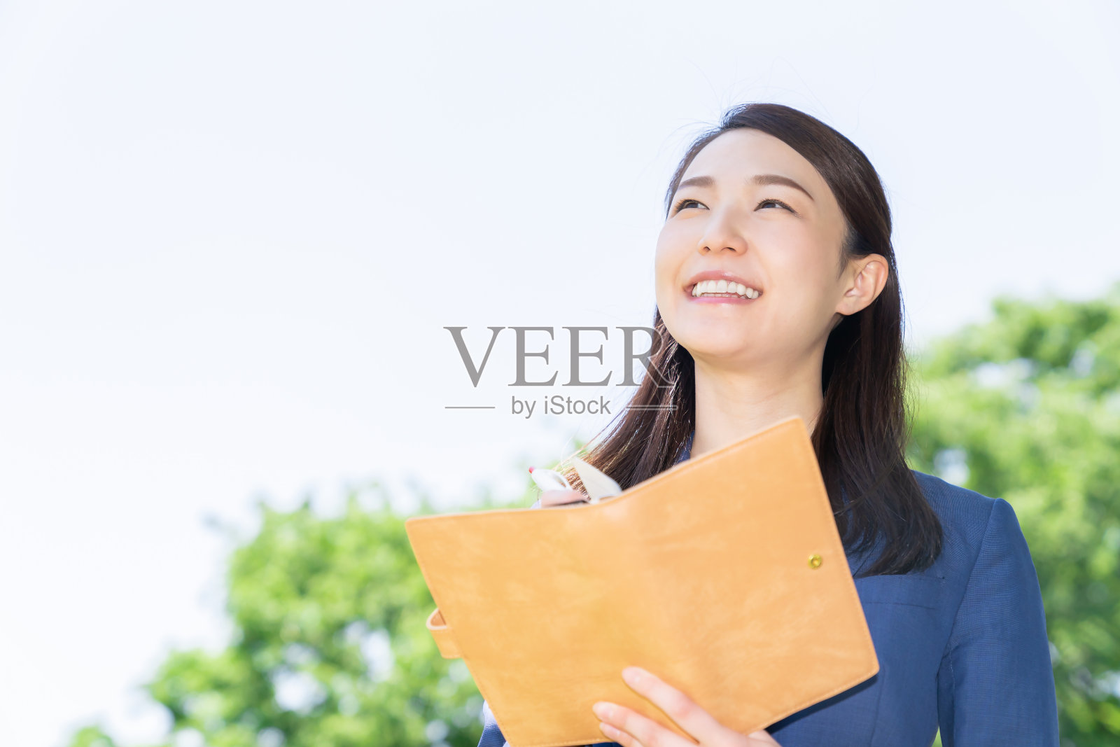 一个在户外填写日程表的亚洲女人照片摄影图片