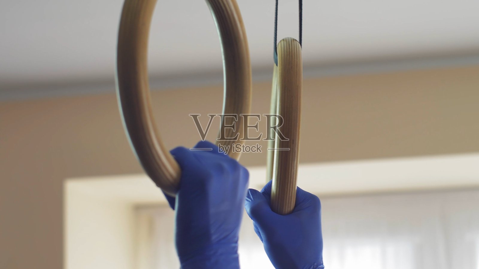 戴着外科口罩的男子在病毒传染病检疫中心练体操环照片摄影图片