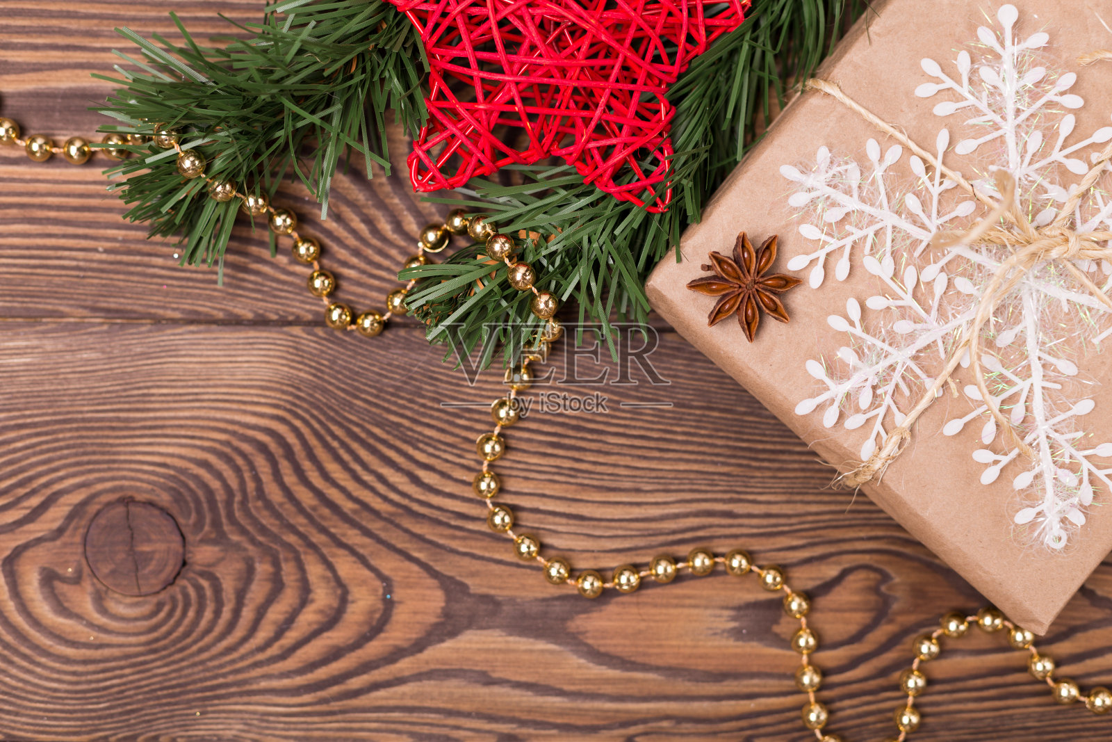 圣诞节和新年假期的背景。装饰礼物，冷杉枝，红藤星，珠子，雪花，肉桂棒在木桌上。平整，空旷照片摄影图片