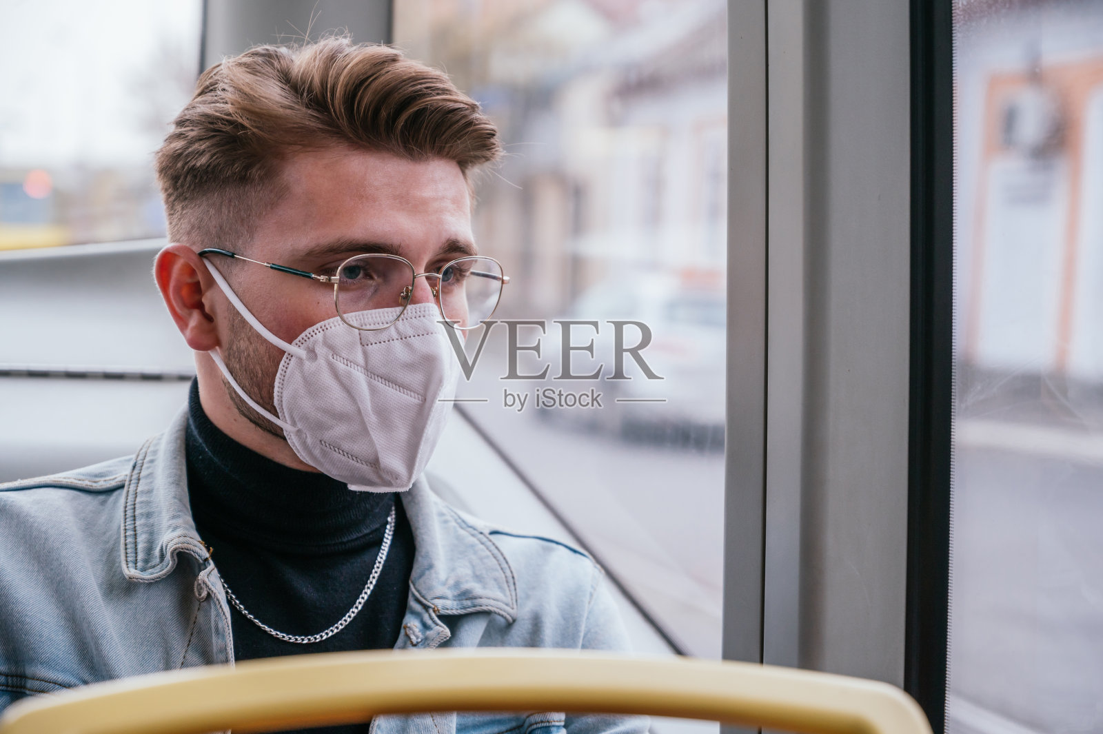 在公共交通工具上戴口罩的年轻人照片摄影图片