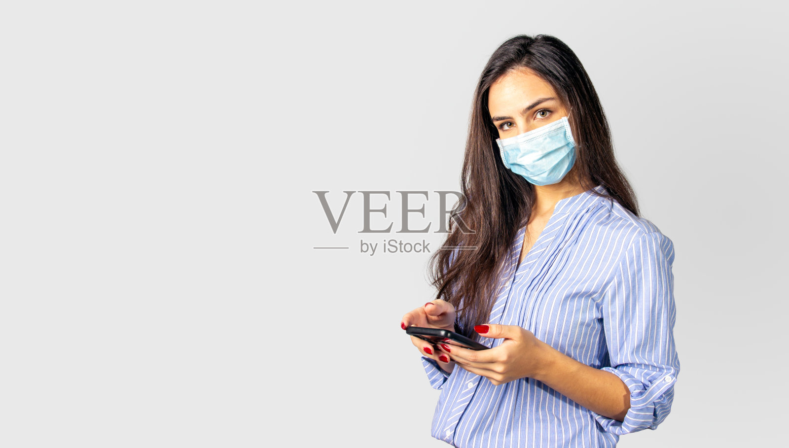 女商人戴着防护面具用手机照片摄影图片