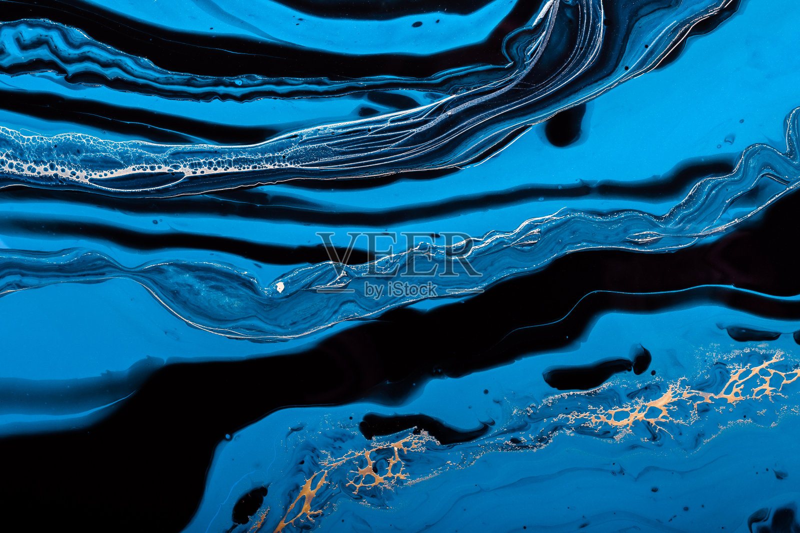 流体艺术。蓝色的抽象海洋中的金色波浪。大理石效果的背景或纹理照片摄影图片