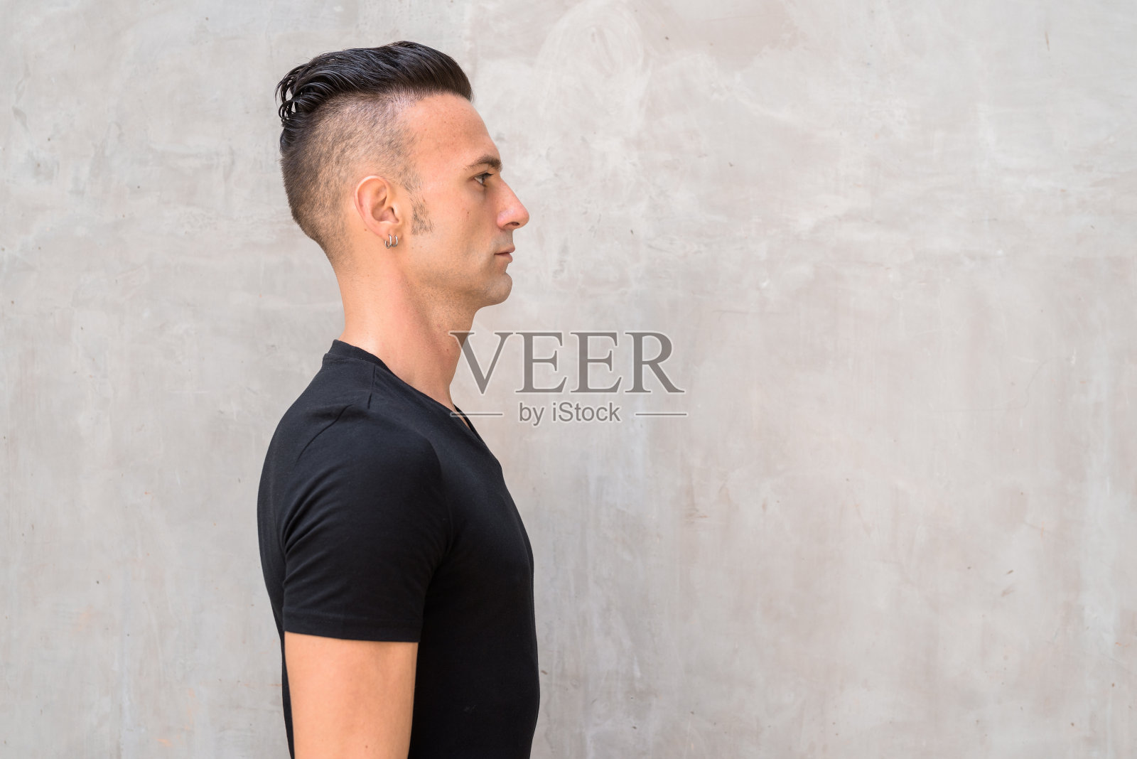 侧面英俊的年轻意大利男子与削弱穿黑色t恤照片摄影图片