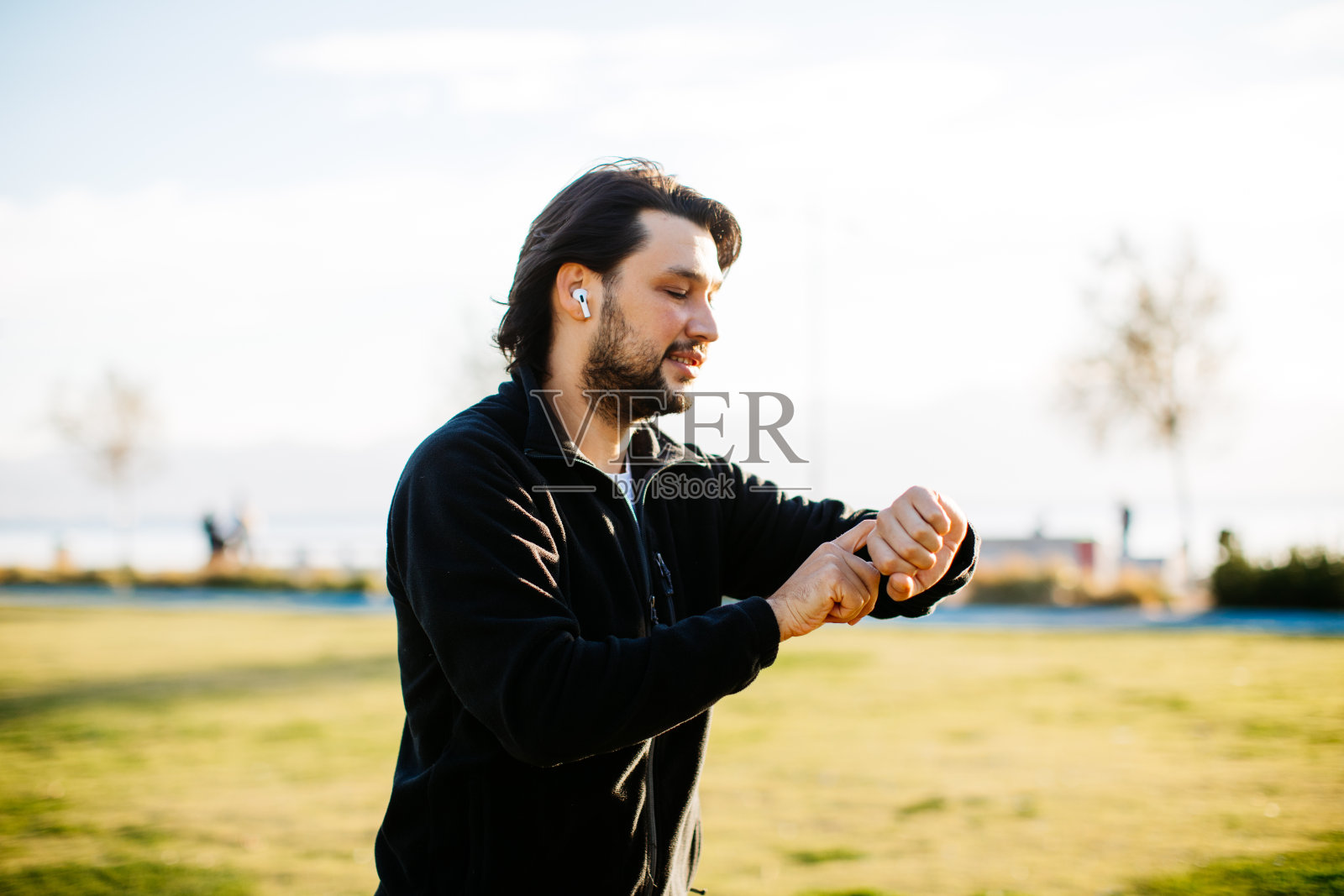 男人在农村跑步锻炼检查智能手表健身活动App照片摄影图片