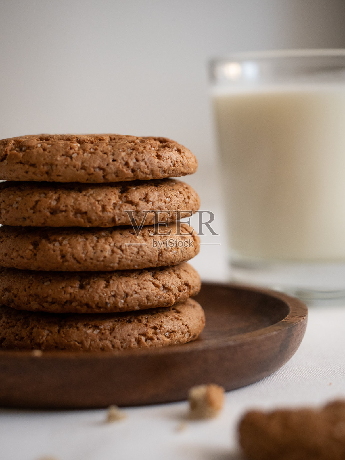 燕麦饼干在一个木制的盘子和一杯牛奶在白色的背景照片摄影图片