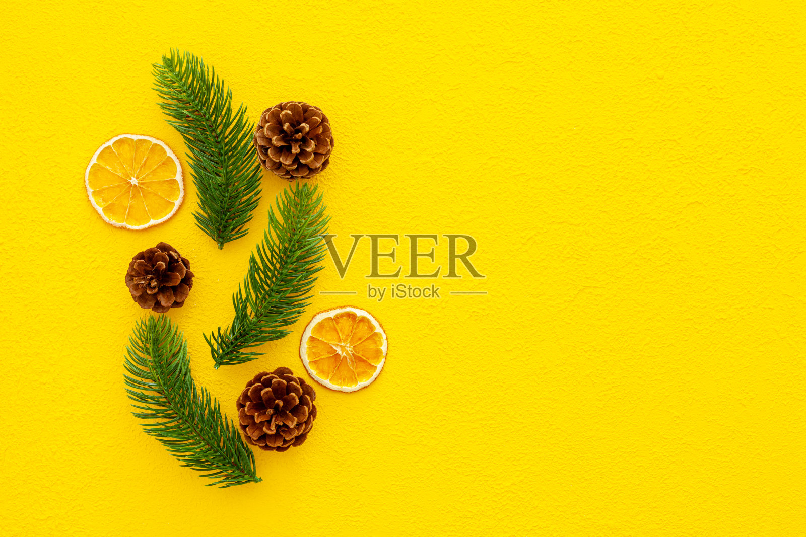 用云杉树枝、圆锥体和古董玩具装饰圣诞节或新年的黄色背景照片摄影图片