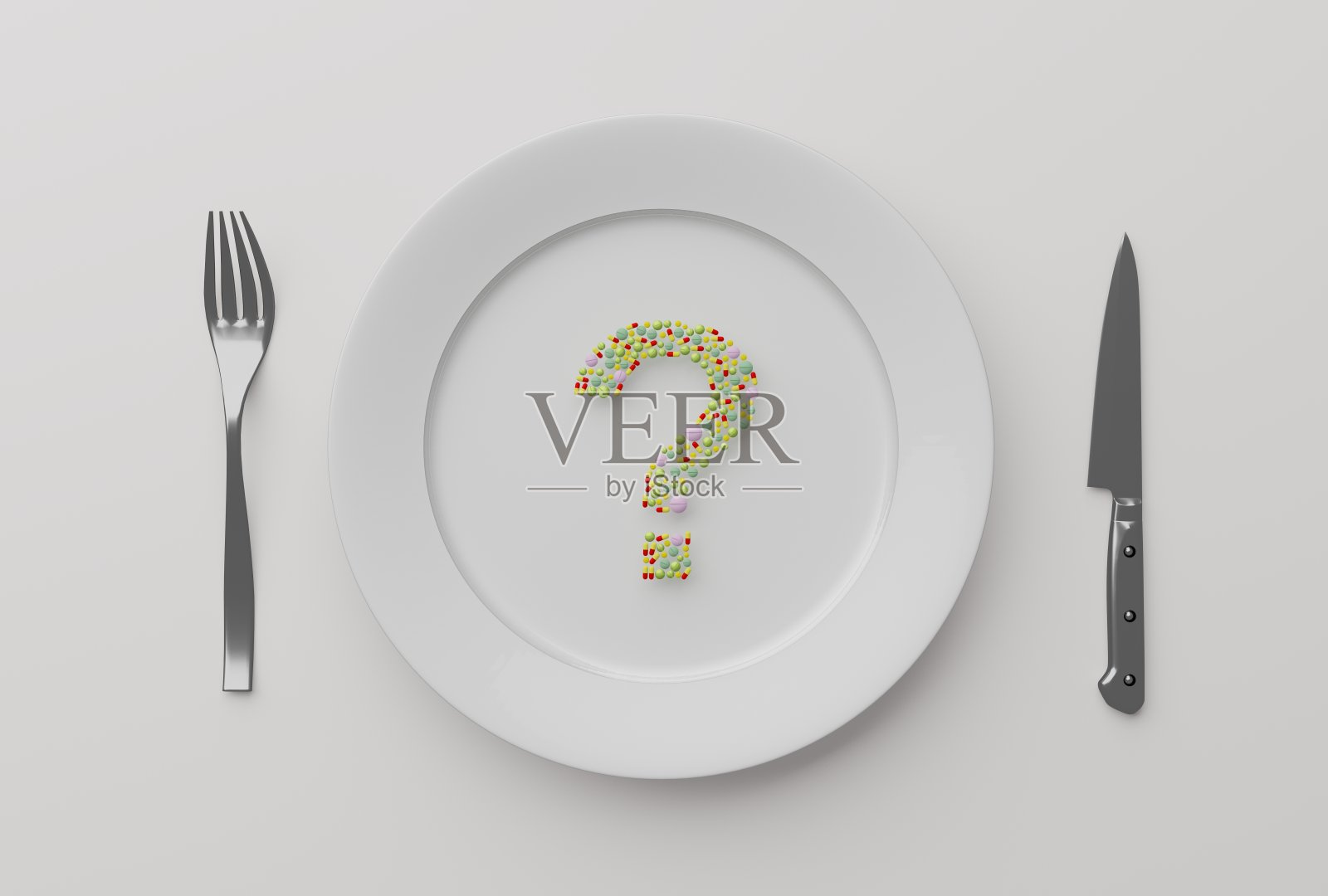 盘子里的药片，背景是刀叉照片摄影图片